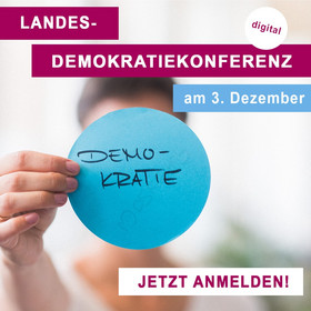 Ein Blatt mit der Schrift Demokratie und darüber ein Datum 3. Dezember