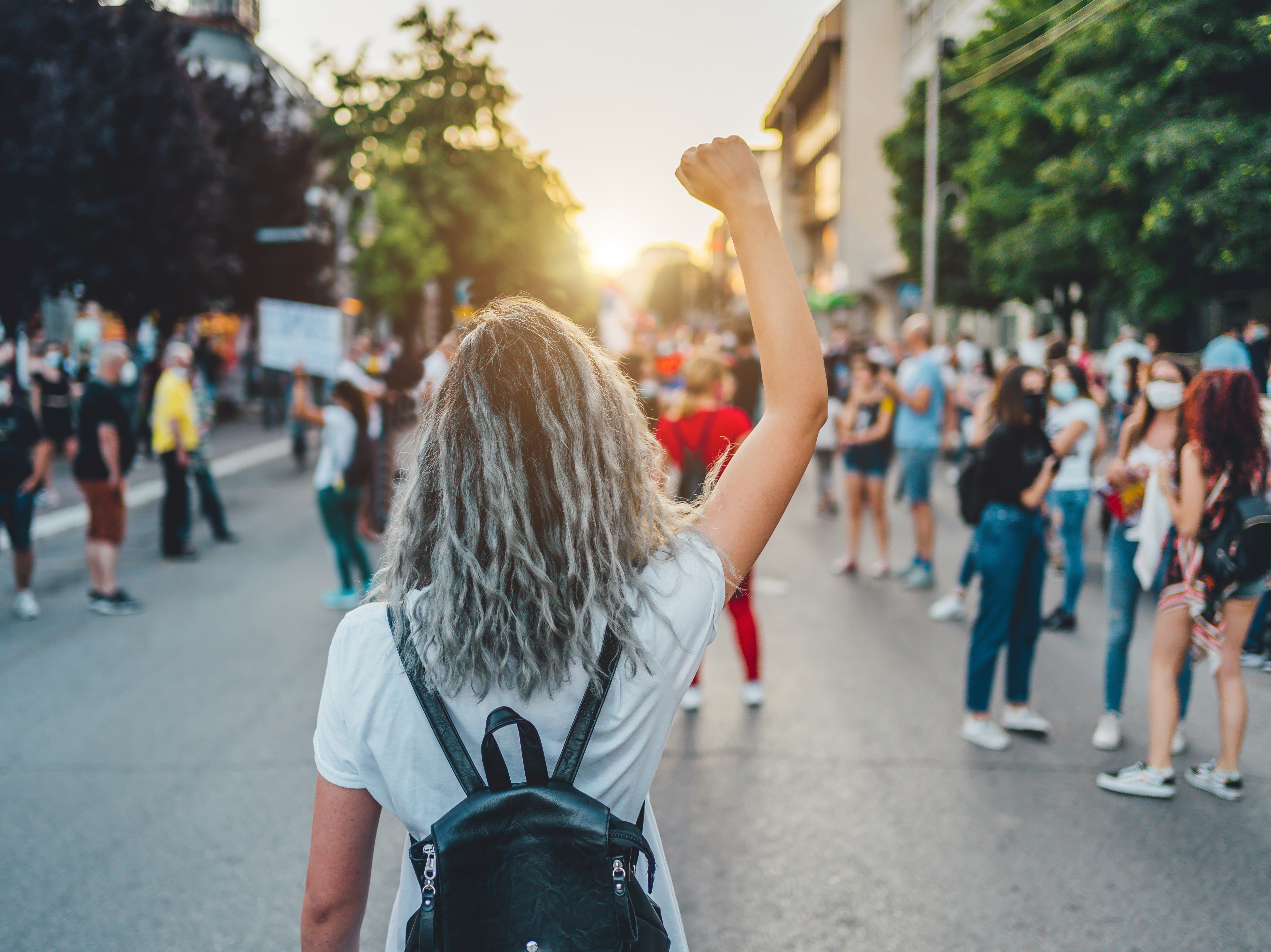 Eine junge Frau hebt die Faust auf einer Protestveranstaltung